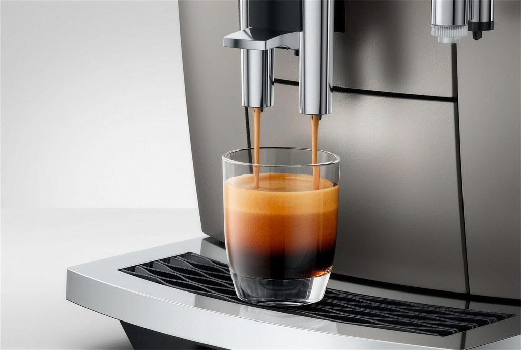 Espresso cayendo con crema densa, cafetera en Midnight Silver