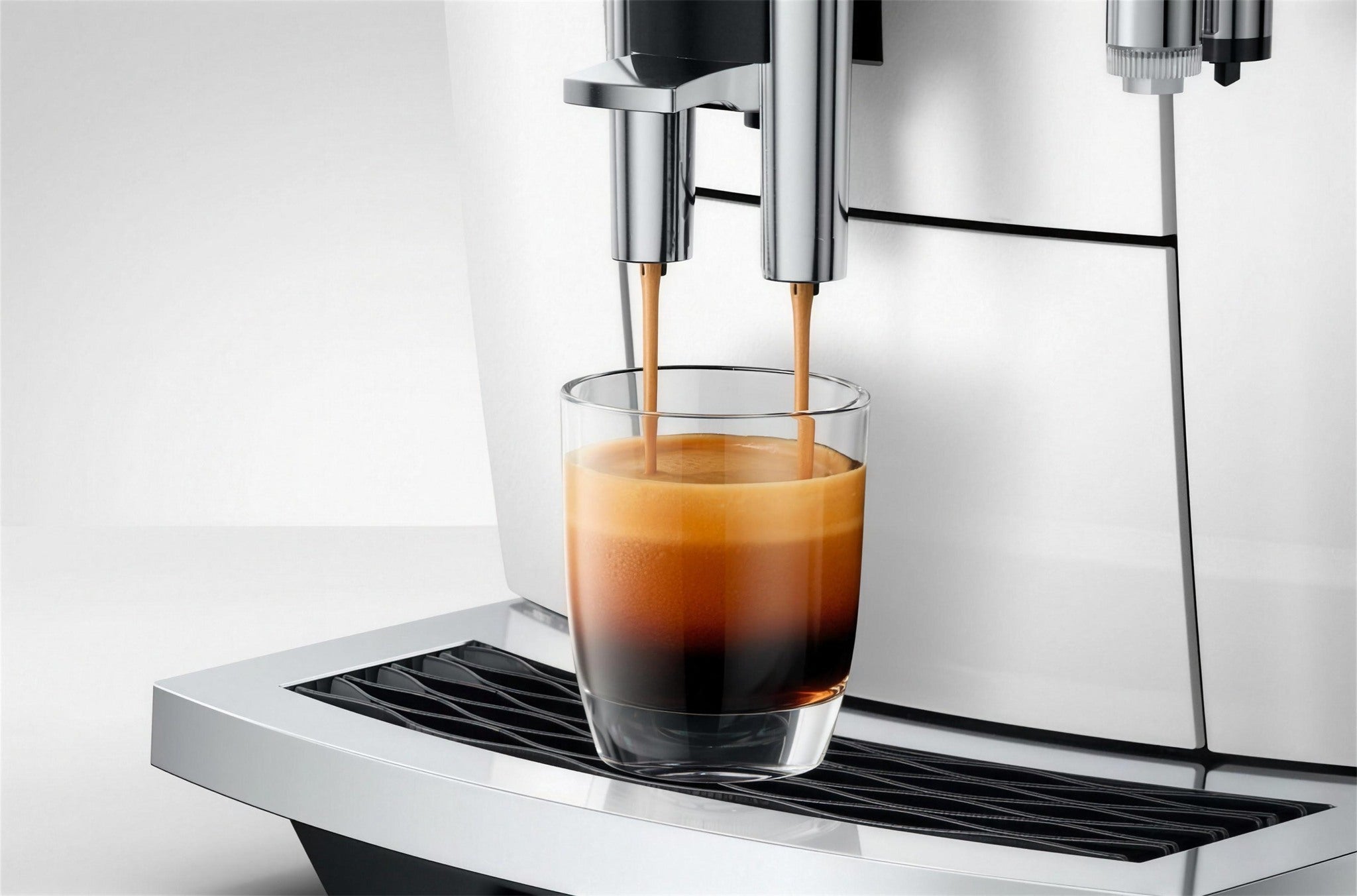 Espresso cayendo con crema densa, cafetera en Piano White